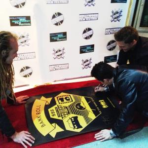 LR Azmyth Kaminski Josh Roman and Doug Maguire sign the film festival poster on the red carpet for their movie Bank Roll at the 2012 Hollywood Reel Independent Film Festival