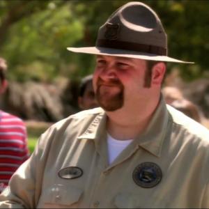 Chris Traeger (Rob Lowe) looks on as Ranger Patrick (Ben Zelevansky) rejects Ron Swanson's permit to slaughter a pig on 