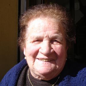 A Sicilian woman in Piana degli Albanesi Sicily smiling for A SICILIAN ODYSSEY crew on location