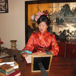 Lil Rhee as Princess Der Ling, writing at the desk