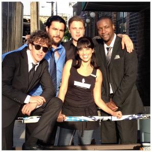 Actress Lisa Catara with cast members Dan Stevens Chris Abbott Michael Pitt and Rob Brown on the set of Criminal Activities directed by Jackie Earl Haley starring John Travolta