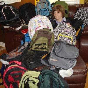 Austin with backpacks he collected ffor Blessings in a backpack charity!!!