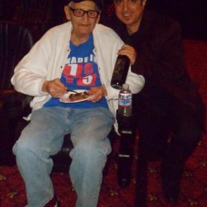 Boris Acosta with Charles Aidikoff during his 100th birthday and Oscars viewing party at his amazing screening room on Rodeo Dr in Beverly Hills. Showing off custom label Dante's Hell Animated bottle of wine, gifted to Mr. Aidikoff.
