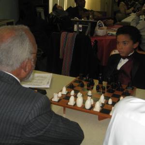 Ethan playing Chess on the set of Cordially Invited Where he played the role of EJ Lacroux