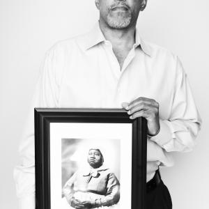Kevin John Goff posing with his aunt's picture (Hattie McDaniel).