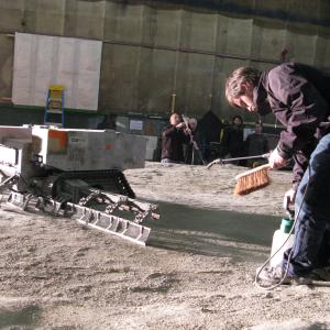 Resetting the 112th scale lunar surface for a shot with a harvester vehicle during the model miniature shoot for Moon 2009
