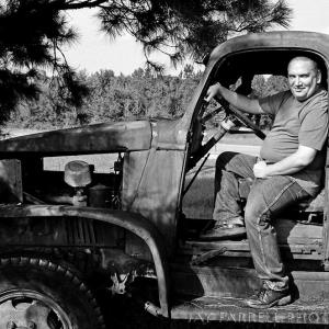 Casual photo of James Magnum Cook sitting in an old truck on his way to St. Simons Island, Georgia.