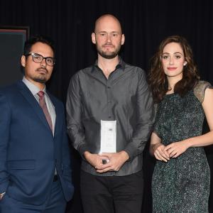 Host Michael Pena winner of the Piaget Producers Award Chris Ohlson and host Emmy Rossum speak onstage during the 2015 Film Independent Filmmaker Grant and Spirit Awards nominee brunch at BOA Steakhouse on January 10 2015 in West Hollywood California