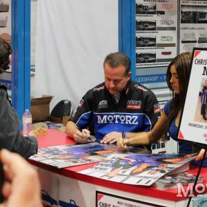 Chris Duke signing posters at the 2012 SEMA Show Las Vegas Convention Center Covercraft Booth