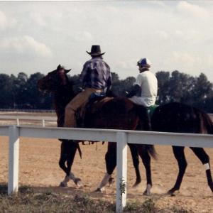 Tommie Sr ponying horses at the track