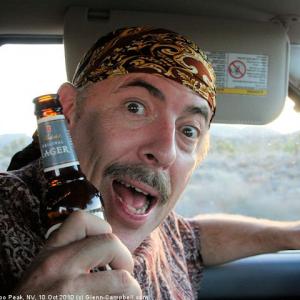 Drinking and driving on a remote dirt road near Area 51 in Nevada. (Glenn actually drinks very rarely. It would take him hours to drink a bottle this size.)