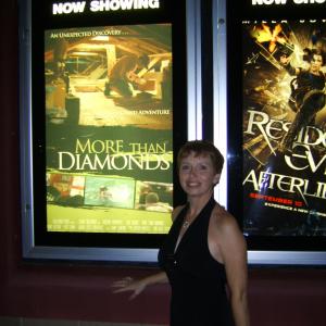 Sonya standing in front of the movie poster of More Than Diamonds