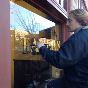 Kevin Signwriting a bar window for 