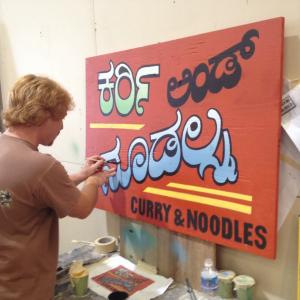 Kevin painting a sign India on Cameron Crowe film in Hawaii