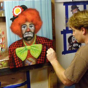 Kevin painting a portrait of the character Carl in clown costume and makeup for Zeke and Luther