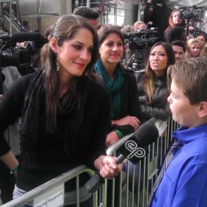Reese Hartwig on the Green Carpet at the premiere of The Muppets Punch Teacher scene with Ken Jeong