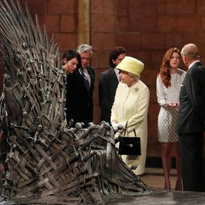 Queen Elizabeth II meets cast members of the HBO TV series Game of Thrones Lena Headey and Conleth Hill while Prince Philip Duke of Edinburgh shakes hands with Rose Leslie as they views some of the props including the Iron Throne on set in Belfasts Titanic Quarter on June 24 2014 in Belfast Northern Ireland The Royal party are visiting Northern Ireland for three days
