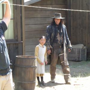 Melody as Adell Kwon with Paul Gross on the set of GUNLESS.