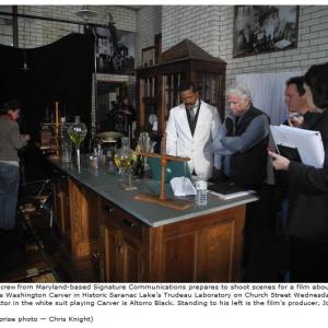 A film crew from Maryland-based Signature Communications prepares to shoot scenes for a film about George Washington Carver in Historic Saranac Lakes Trudeau Laboratory on Church Street Wednesday. The actor in the white suit playing Carver is Altorr