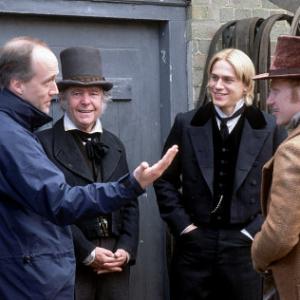 WriterDirector DOUGLAS McGRATH discusses a scene with actors TOM COURTENAY CHARLIE HUNNAM and KEVIN McKIDD left to right on the set