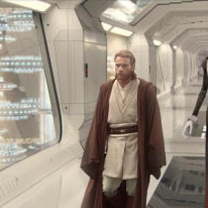 Jedi ObiWan Kenobi actor Ewan McGregor walks down a corridor amazed by what he sees in the huge cloning facility on the planet Kamino He is followed by Prime Minister Lama Su and aide Taun We
