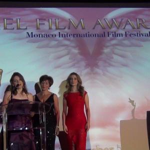 Film Director Jolanda Ellenberger left thanks the jury and audience for her BEST HUMANITARIAN SHORT FILM ANGELS AWARD at the Monte Carlo award ceremony on December 7 2013 Film Producer Daniella Gonella middle  Actress Antonella Savucci right
