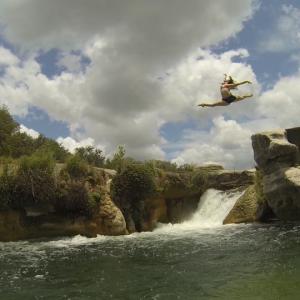 Caitlin leaping from Dolan Falls Texas