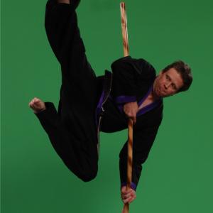 Martial art strike while balancing on a staff.