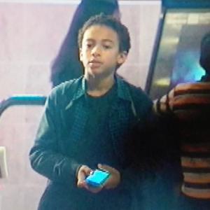 Javi (Jaden Betts) waits for online gaming friend at arcade while Huck (Guillermo Diaz) watches from a far on SCANDAL.