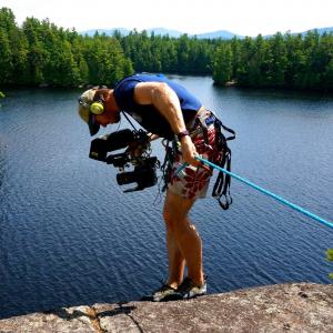 Producer/Editor/DP Rufus Lusk hangs off a cliff in the Adirondack's to capture a camper rock climbing.