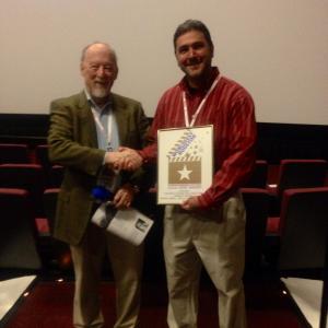 Hunter Todd, Founder of WorldFest Houston, awarding a Gold Remi Award to Michael Gibrall for the feature film 