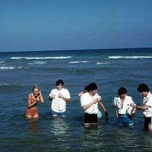 The Beatles Paul McCartney John Lennon ringos Starr George Harrison playing in the water joined by two girls