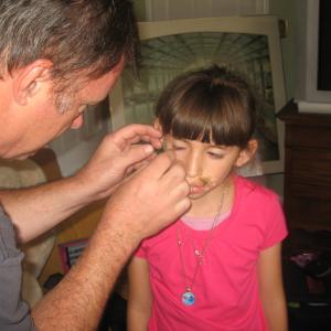 Rick L. Baker applying special effects makeup to Natalie Miranda on the set of 