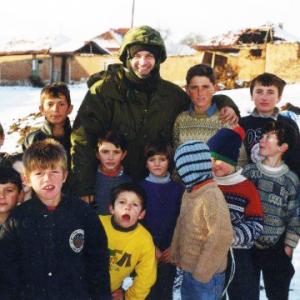 Mark Terry with the homeless children of Kosovo during the filming of We Stand on Guard, 2000.