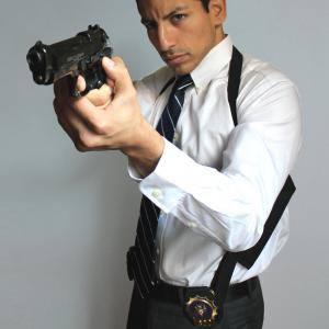 Detective Alexander Cortes (Alex Kruz) draws his weapon.