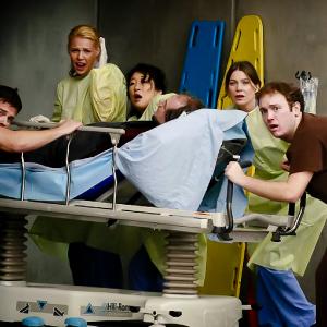 Production still from Grey's Anatomy. From left to right: Katherine Heigl, Sandra Oh, John Billingsley, Ellen Pompeo, & Adam Graham