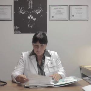 Dr. Eve Pullman, inventor of the FVMRI procedure, in her office reviewing Henri Miller's medical file.
