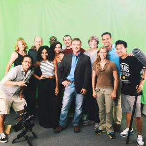 Behind the scenes on a green screen set with cast and crew