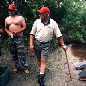 Director Paul Sullivan discusses a scene with Chris Elliott as alligator wrangler Tim Williams watches on