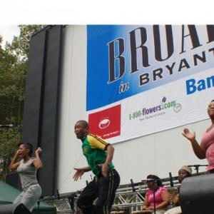 LeeAnet Noble in gray performing at Broadway in Bryant Park with the cast of Drumstruck