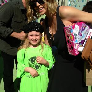 Actress Abigail Zoe Lewis meets Charlize Theron at the Points of Light generationOn Block Party on April 18 2015 in Los Angeles California