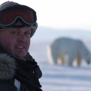 Jason Roberts presenting to camera with a Polar Bear as backdrop!