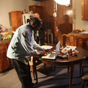 Director Bruce B. Gordon working out production design and prop issues on the computer, while camera assistant James Souter and the 