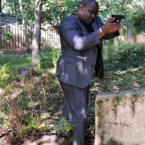 Actor Therron Dumas taking aim at an assailant in 