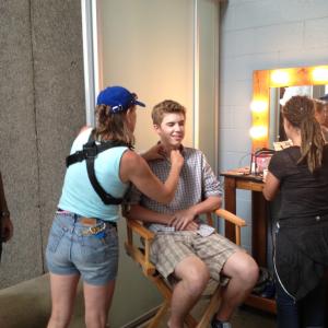 Alex Reininga getting make up done and getting his mic put on at the same time