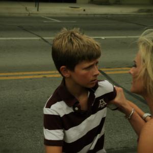 Whitley Perryman portraying young Jon is pulled away from being run over by by a truck by his Mom played by Sherrie Harwell in a scene from Jakes Song