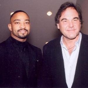 Actor Dennis Jay Funny and WriterDirectorProducer Oliver Stone posing for press at Any Given Sunday premiere in Time Square NYC