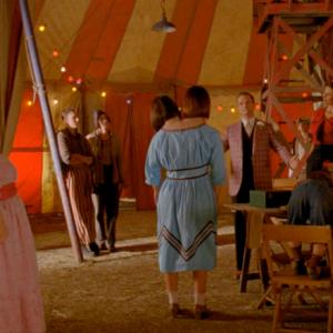 Neil Patrick Harris (as Chester) entertains the Freak Show in this still from American Horror Story: Freak Show showing actor Jerrad Vunovich (Second character from left, leaning on pole)