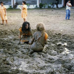 Pamella DPella as Paula in the famous mud fight scene from Caged Heat 2