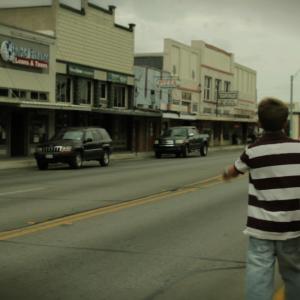 Whitley Perryman playing the role of young Jon begins to step out in front of a truck in a scene from Jakes Song